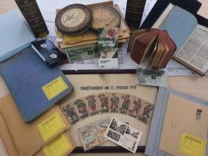 Bild vergrößern: Präsentation verschiedener Bestände und Medien im Archiv: Akten, Sammlungen, Postkarten, Filme, Bücher