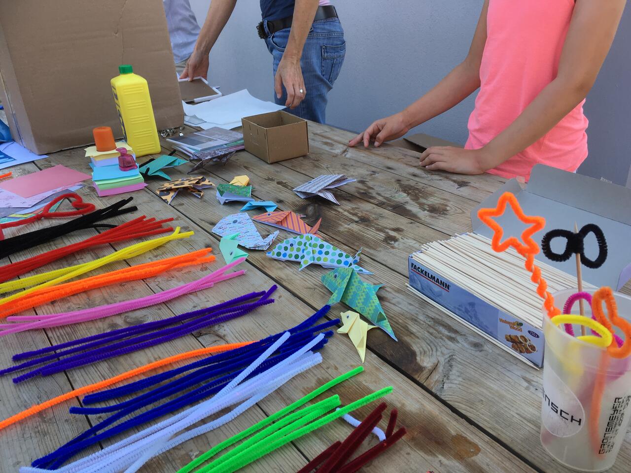 Bild vergrößern: Tisch mit Papier und Stoffen zum Basteln