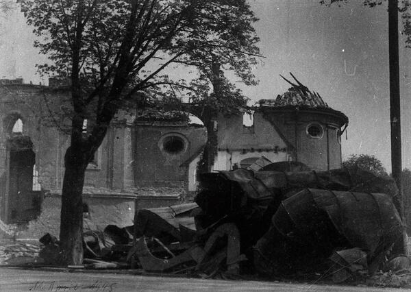 Bild vergrößern: Ruinen der Kirche St. Anton mit stark zerstörtem Dach. Trümmer und ein Baum vor der Kirche. 11. April 1945