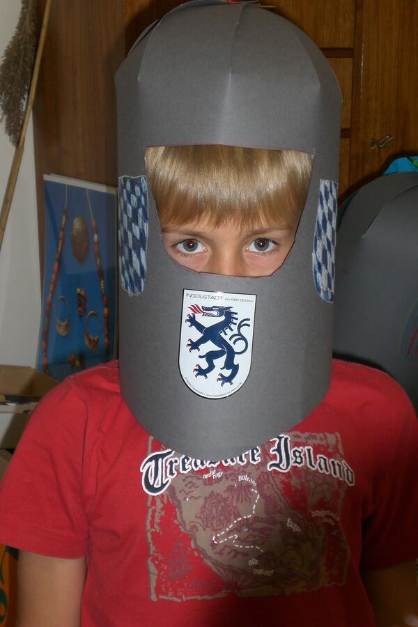 Bild vergrößern: Junge mit selbstgebasteltem Ritterhelm aus Papier