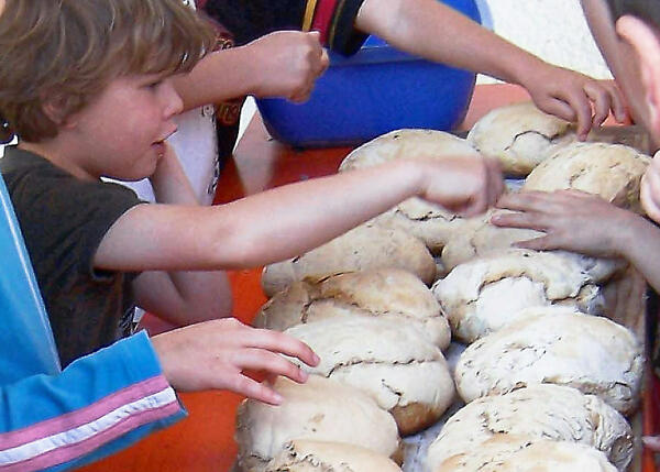 Bild vergrößern: Kinder beim Brotbacken